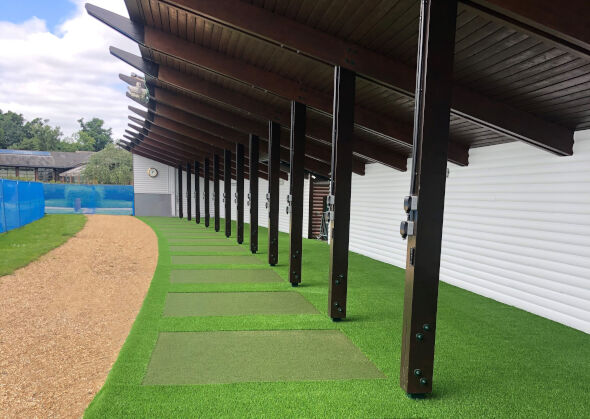 Tucson Covered outdoor tee line with light green synthetic grass boxes inside a dark green synthetic grass strip